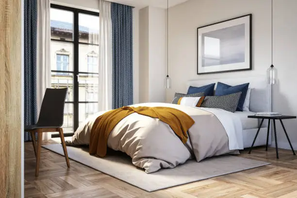 Cozy bedroom featuring a large bed with patterned pillows, a warm throw, and stylish decor near a window.