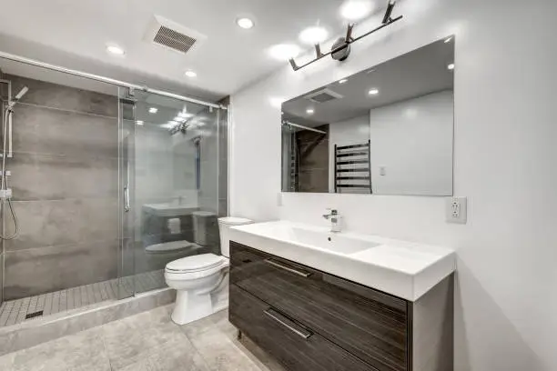 Modern bathroom featuring a glass shower, sleek vanity, and contemporary fixtures.