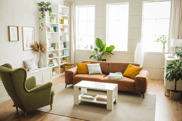 Stylish and inviting living room featuring a brown sofa, green accent chair, and large windows with natural light.