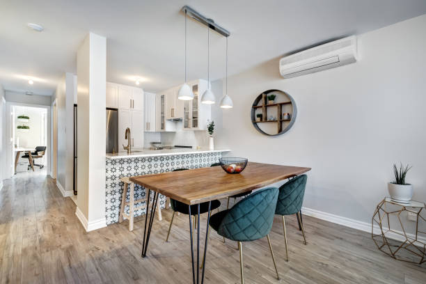 Modern dining area featuring a stylish wooden table, teal chairs, and a contemporary kitchen backdrop.