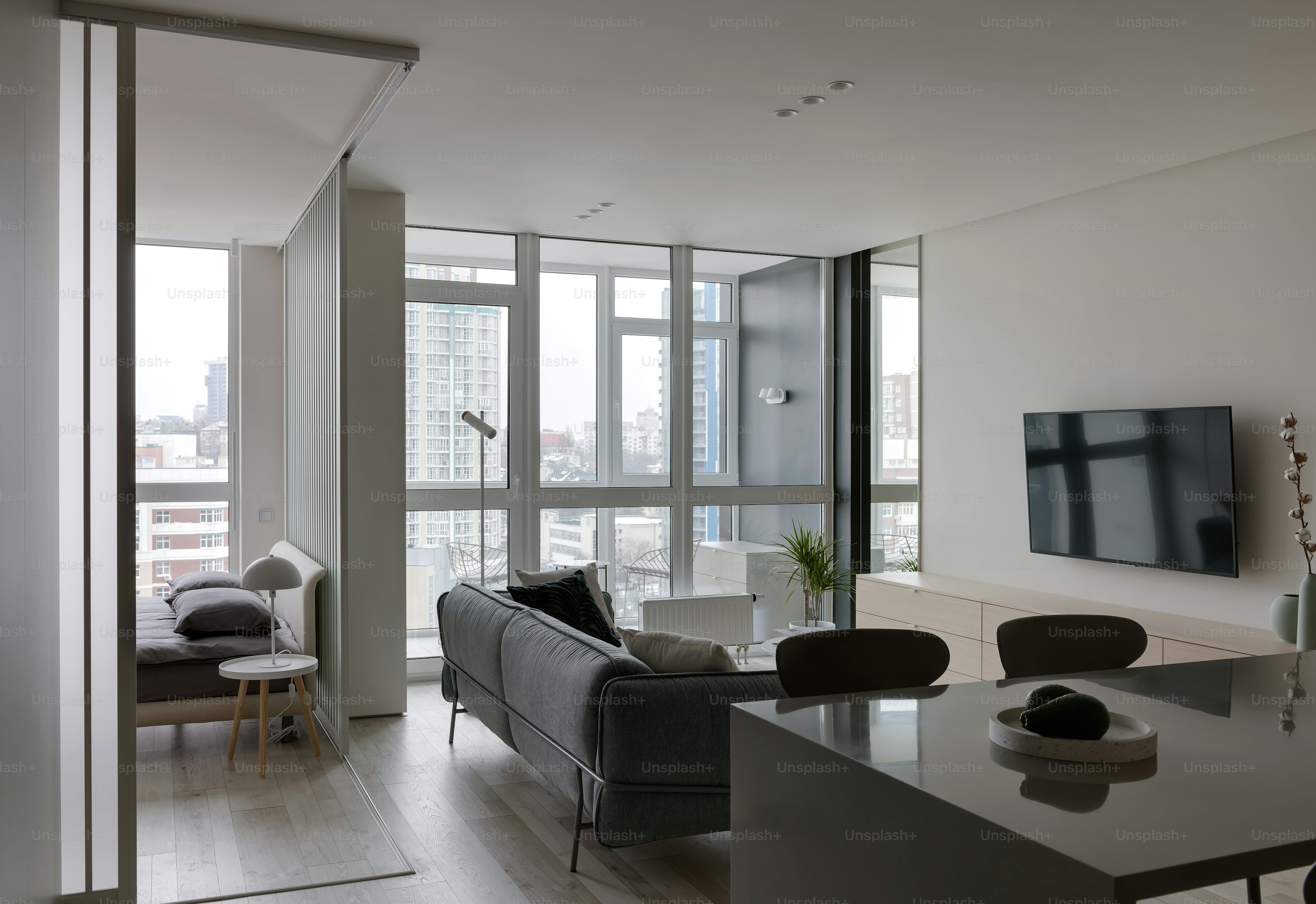 Modern living room featuring large windows, a sofa, and a minimalist design.