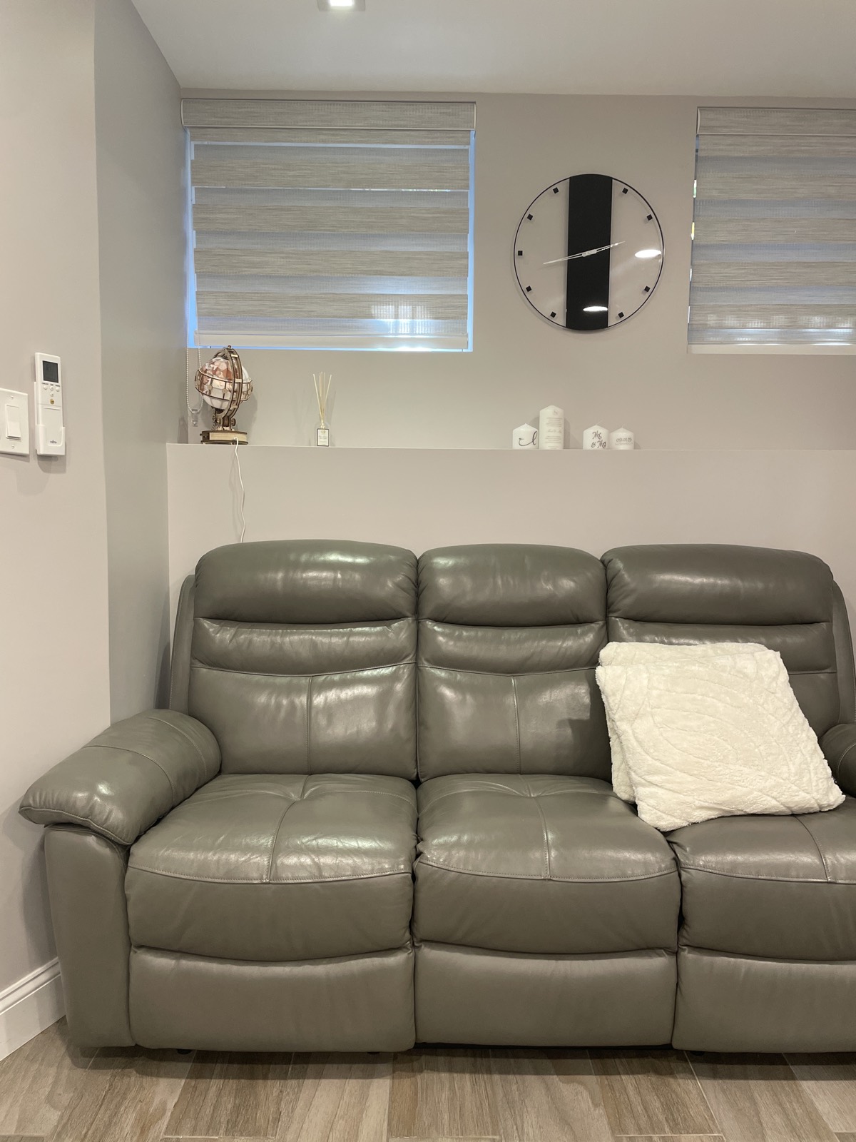 Modern living room with a gray leather sofa and decorative accents.