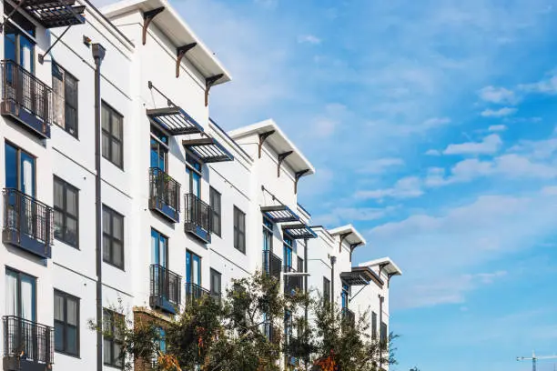 Modern apartment building with balconies against a blue sky.